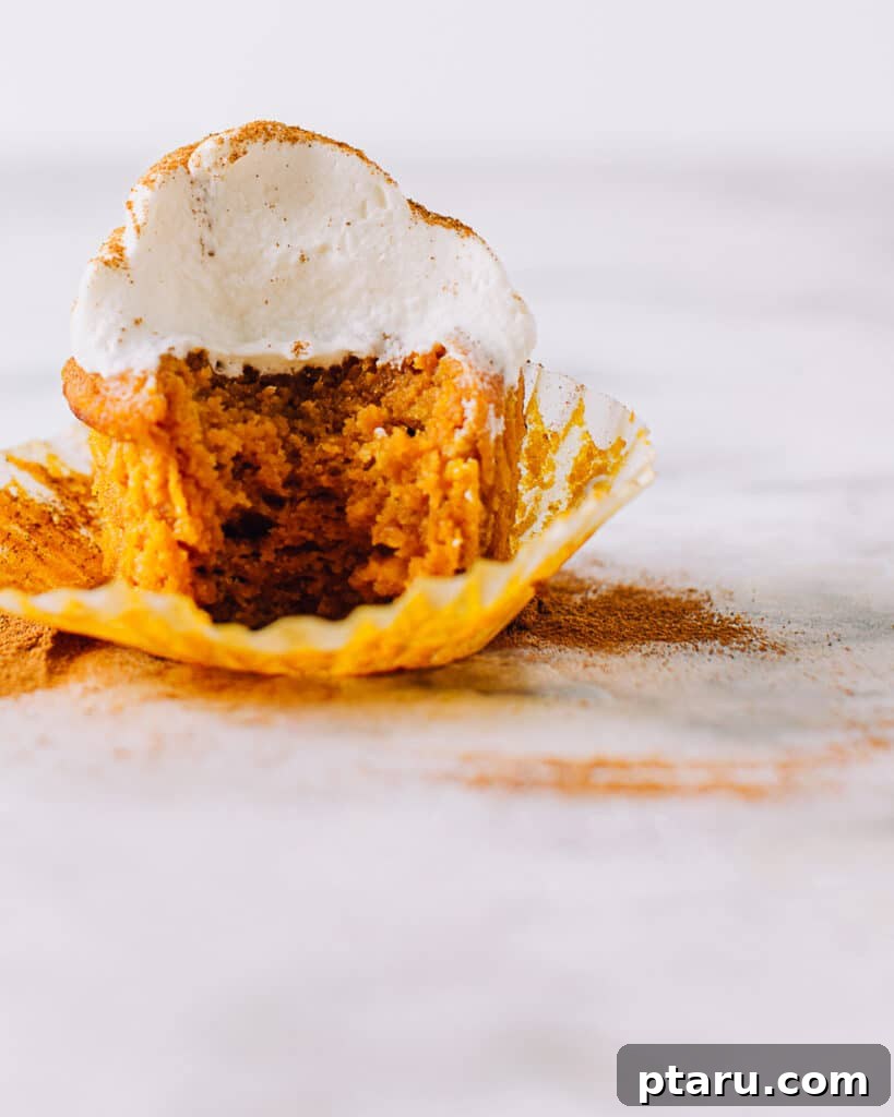 Effortless Velvety Pumpkin Cupcakes 6 Pumpkin cupcake with a bite taken out.