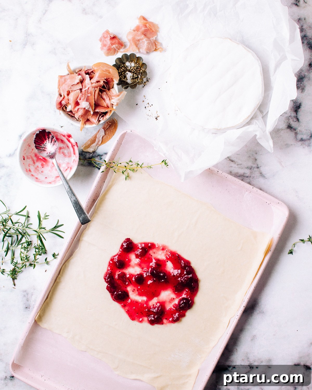 Golden Puff Pastry Brie with Prosciutto and Cranberry 4 Spreading cranberry sauce on puff pastry.