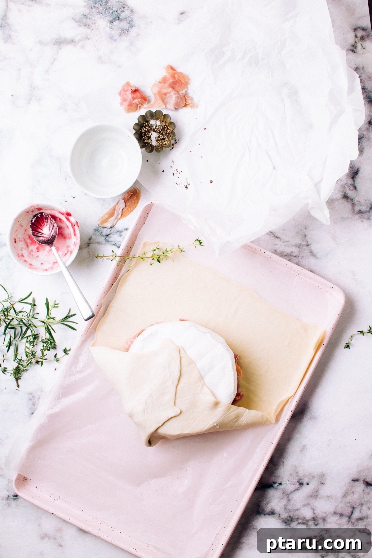 Golden Puff Pastry Brie with Prosciutto and Cranberry 7 Using parchment paper to shape wrapped brie.