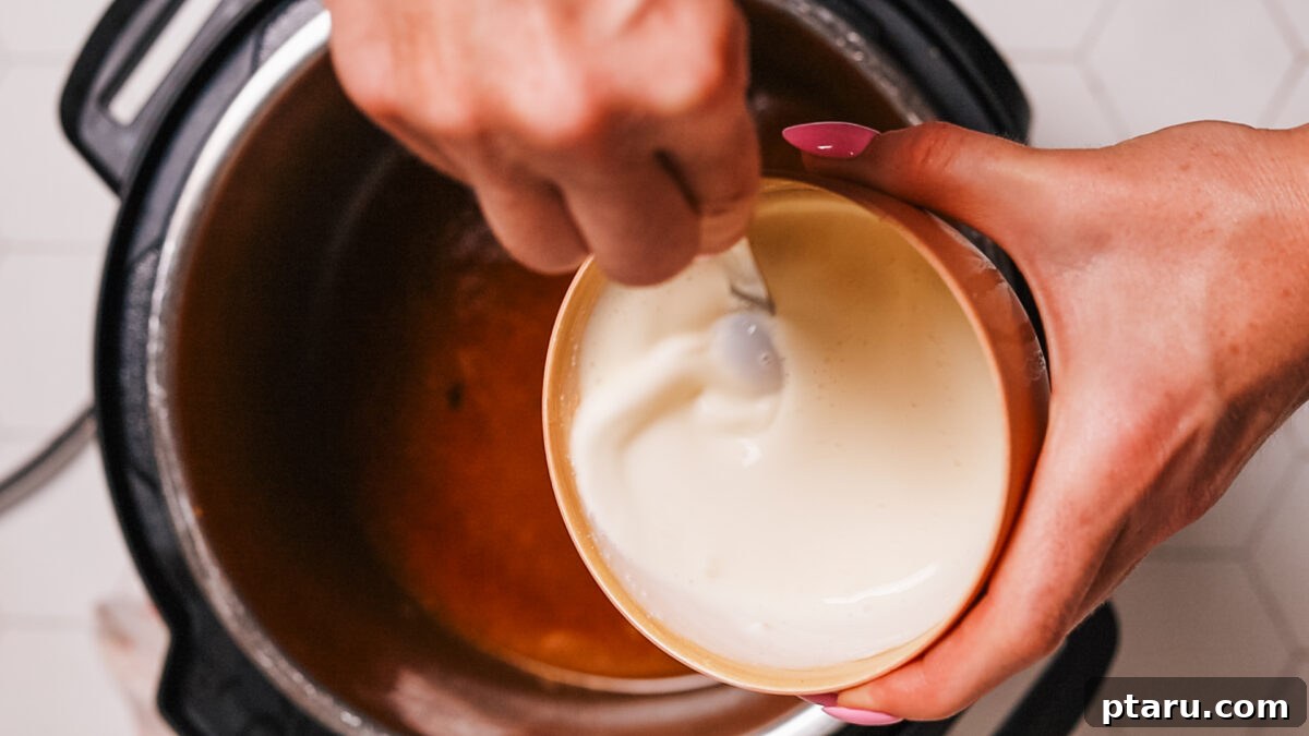 Zesty Slow Cooker Lemon Chicken 7 Mixing heavy cream and cheese into the gravy.