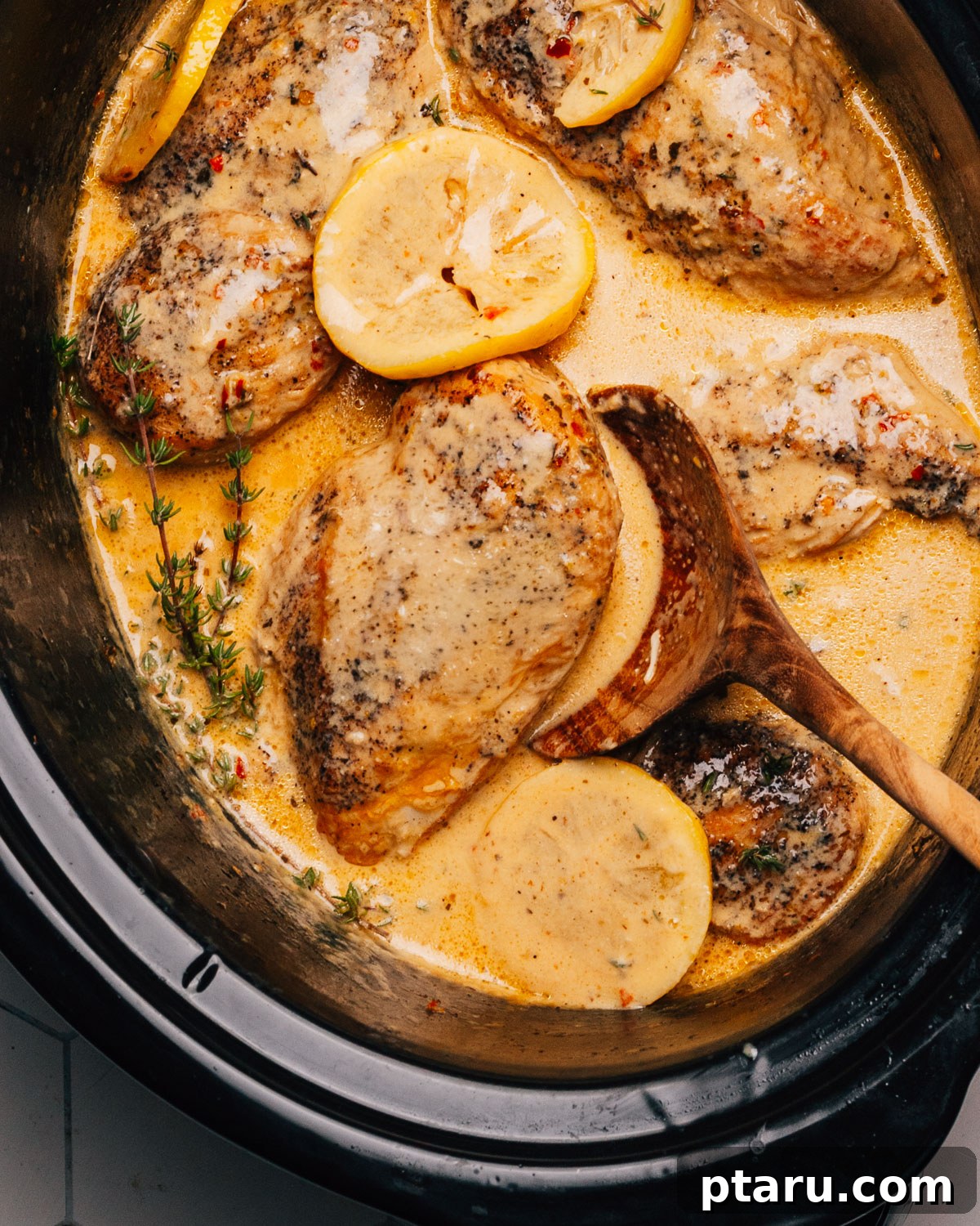 Zesty Slow Cooker Lemon Chicken 8 Crockpot Lemon Chicken served with a wooden spoon.