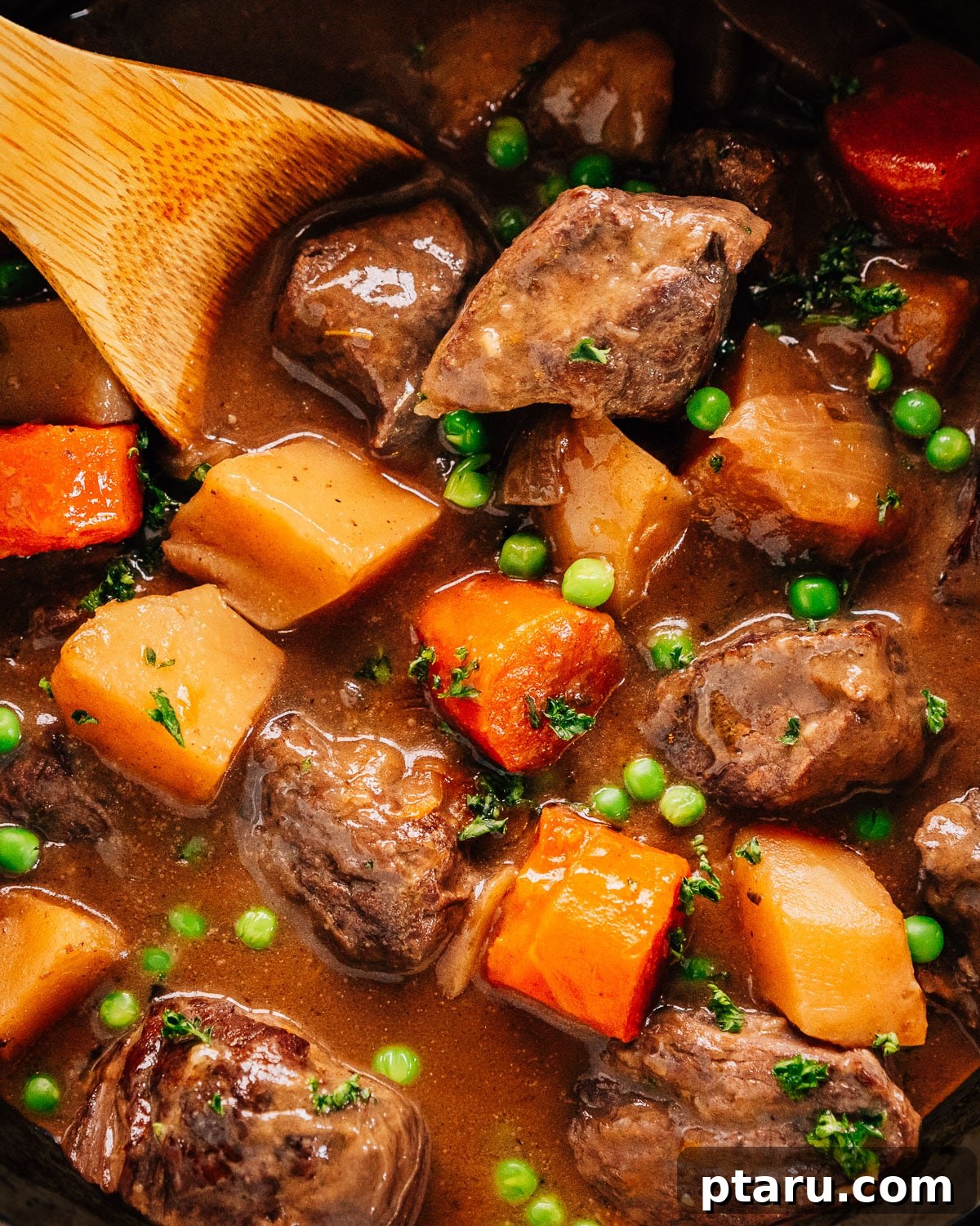 Quick Comfort Beef Stew 2 A steaming bowl of rich Pressure Cooker Beef Stew in an Instant Pot, garnished with fresh parsley, with a wooden spoon resting inside, ready to be served.