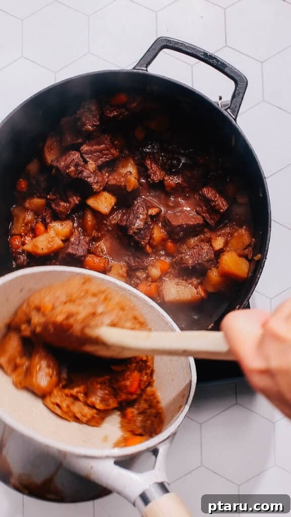 Quick Comfort Beef Stew 8 Step 5: Whisking the prepared butter and flour roux into the hot broth, creating a smooth and thick gravy for the stew.
