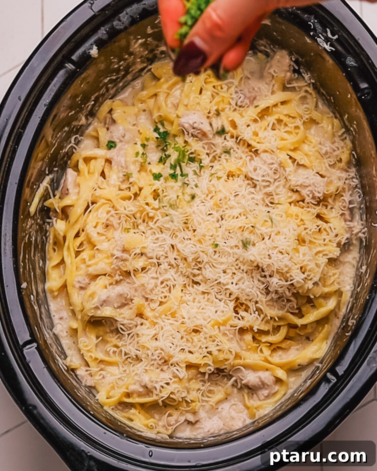 Creamy Slow Cooker Chicken Alfredo 9 Step 6: Combining cooked pasta with the creamy Alfredo sauce and shredded chicken.