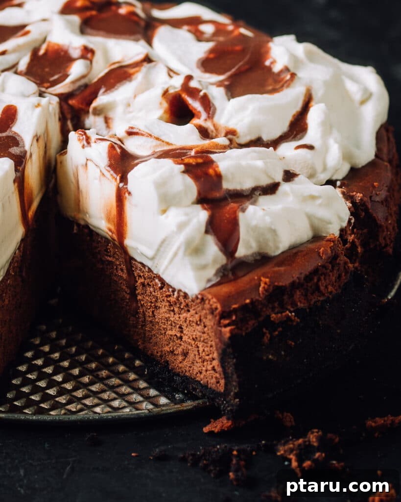 Valentines Sweet Indulgences 7 Chocolate cheesecake with whipped cream and chocolate drizzle with a slice cut.