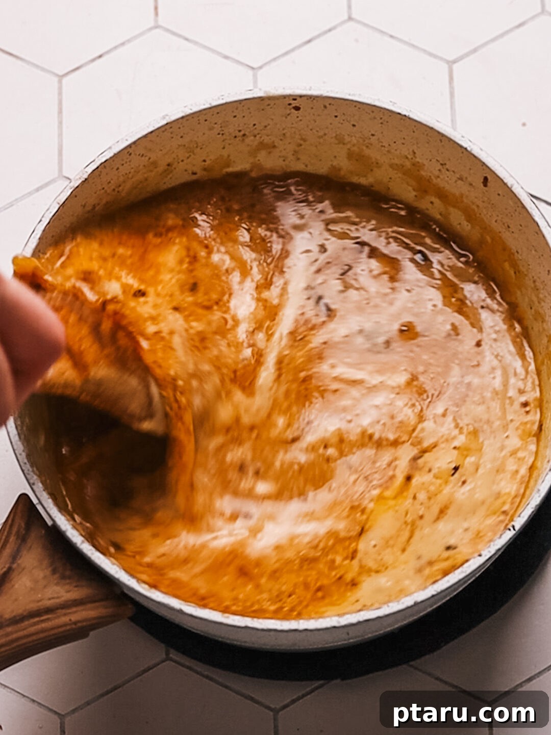 Rich Pork Gravy 10 Close-up of the rich and creamy pork gravy being whisked in a saucepan.