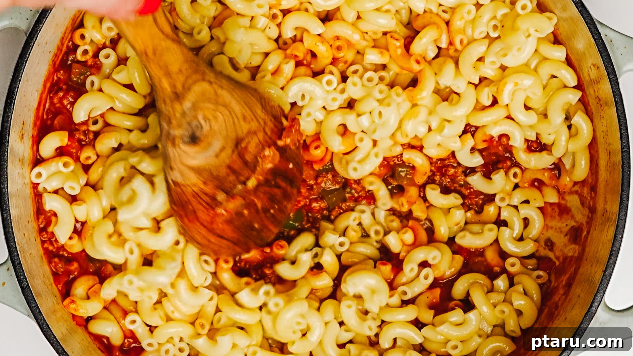 Classic Macaroni Goulash 7 Step 4: Stirring in tomato paste and other sauce ingredients into the pot, creating a rich base for American Chop Suey.