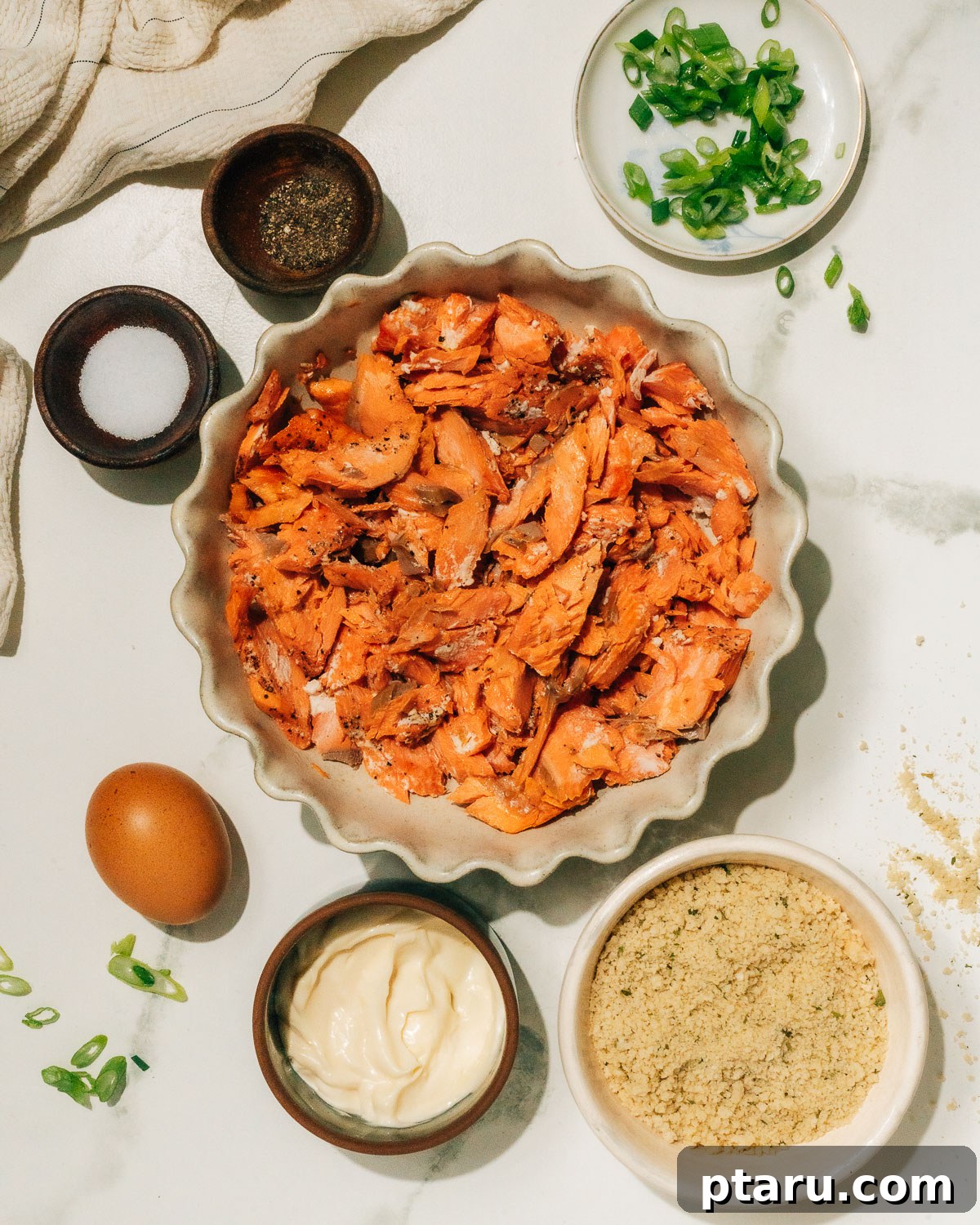 Simple Salmon Patties Ingredients All the fresh ingredients for salmon patties laid out on a table, including canned salmon, panko, egg, mayonnaise, and green onions.