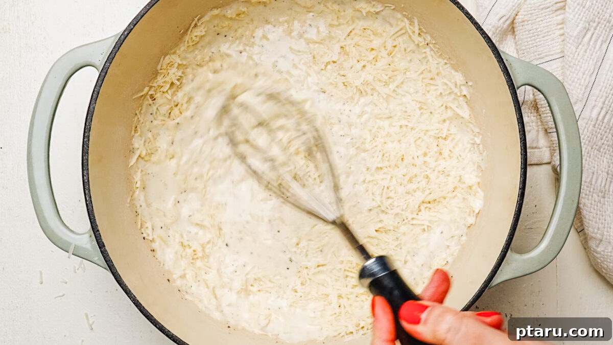 Creamy Chicken Alfredo Perfection 5 Whisking freshly grated Parmesan cheese into a simmering cream sauce to create a smooth alfredo sauce.