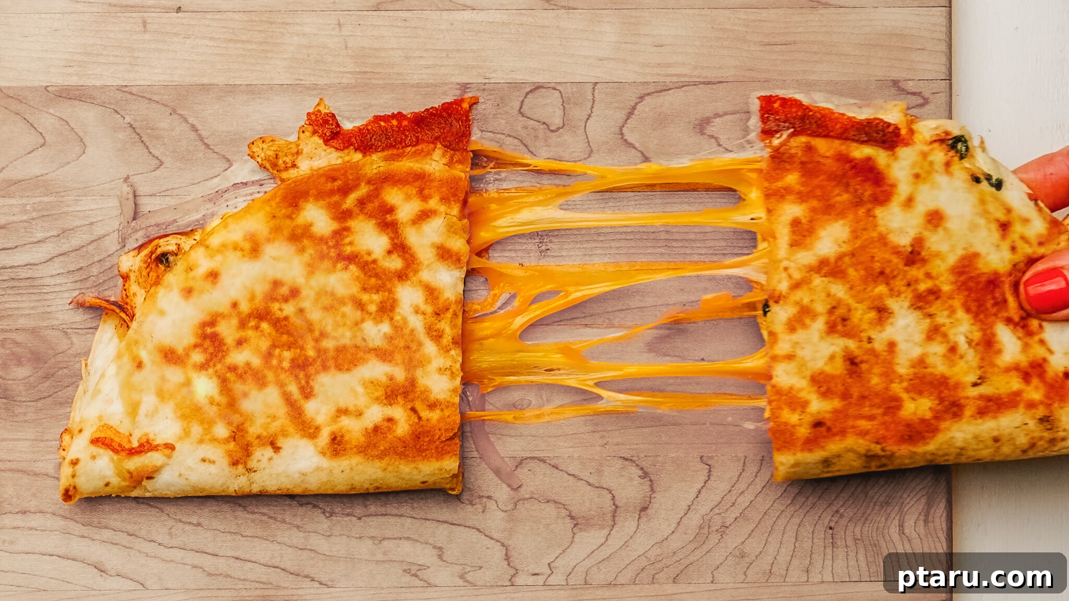 Fiesta Chicken Quesadilla 4 Close-up of a chicken quesadilla with a generous cheese pull, cut into wedges on a wooden cutting board.