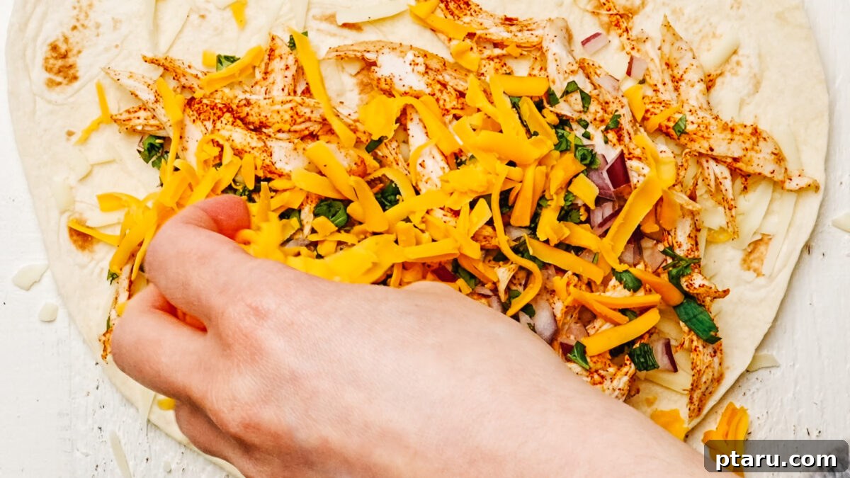 Fiesta Chicken Quesadilla 6 Assembling a chicken quesadilla with layers of cheese, seasoned chicken, diced onion, and cilantro on a large flour tortilla.