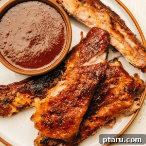 Spare ribs on a plate with barbecue sauce.
