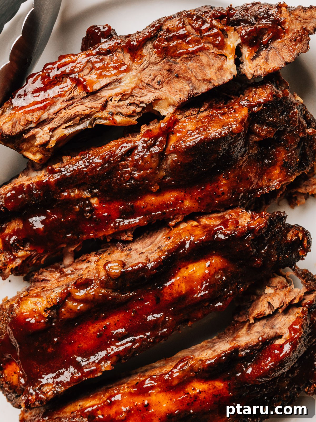 Slow Roasted Tender Beef Ribs 2 Oven baked beef ribs recipe finished on a plate, garnished and ready to serve.