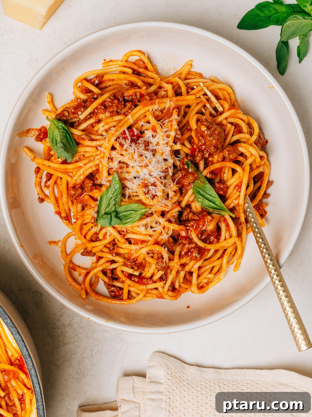 Hearty Beef Spaghetti Made Simple 2 Spaghetti with ground beef recipe plated and ready to serve, garnished with fresh basil and Parmesan cheese.