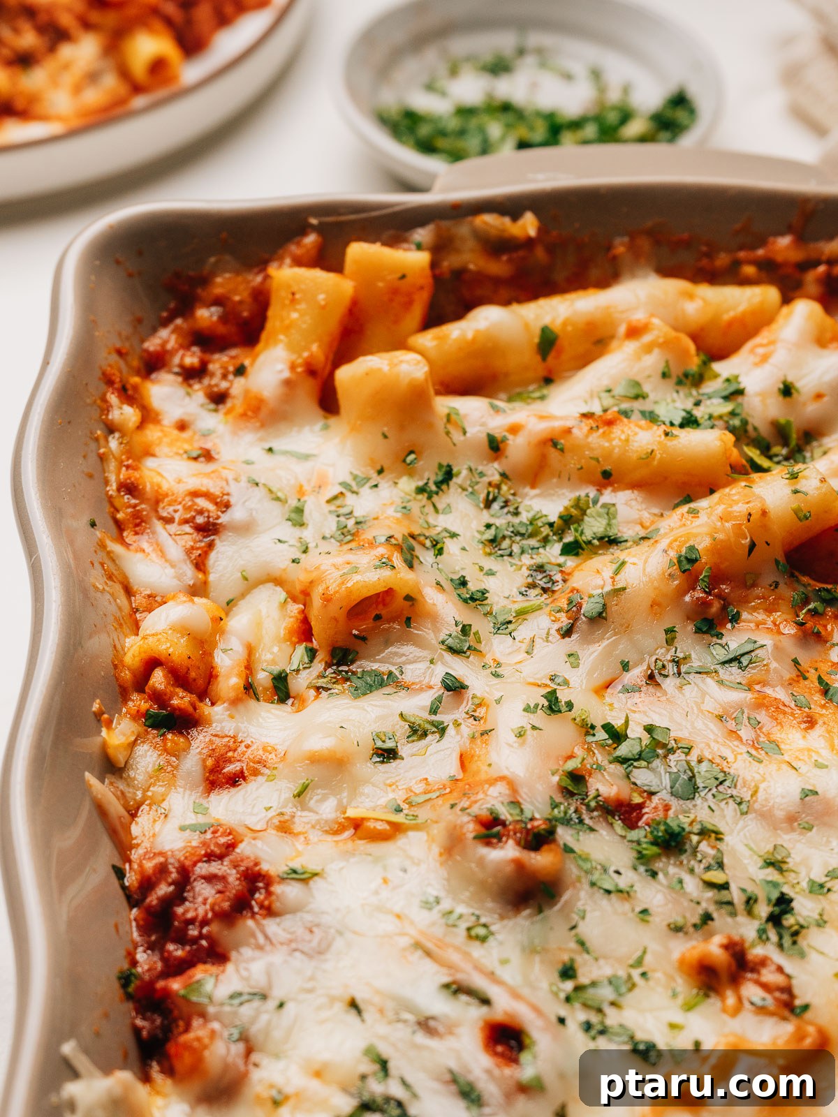 Ultimate Ricotta Ziti Bake 2 Baked Ziti with Ricotta fresh from the oven with golden bubbling cheese and fresh herbs, ready to be served.
