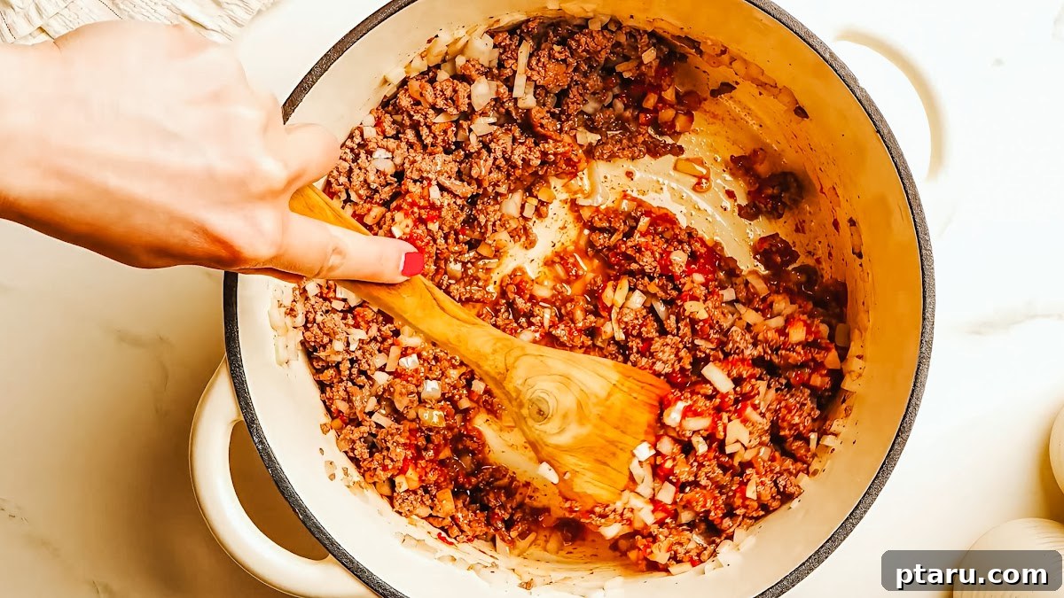 Ultimate Ricotta Ziti Bake 5 Ground beef browning in a Dutch oven