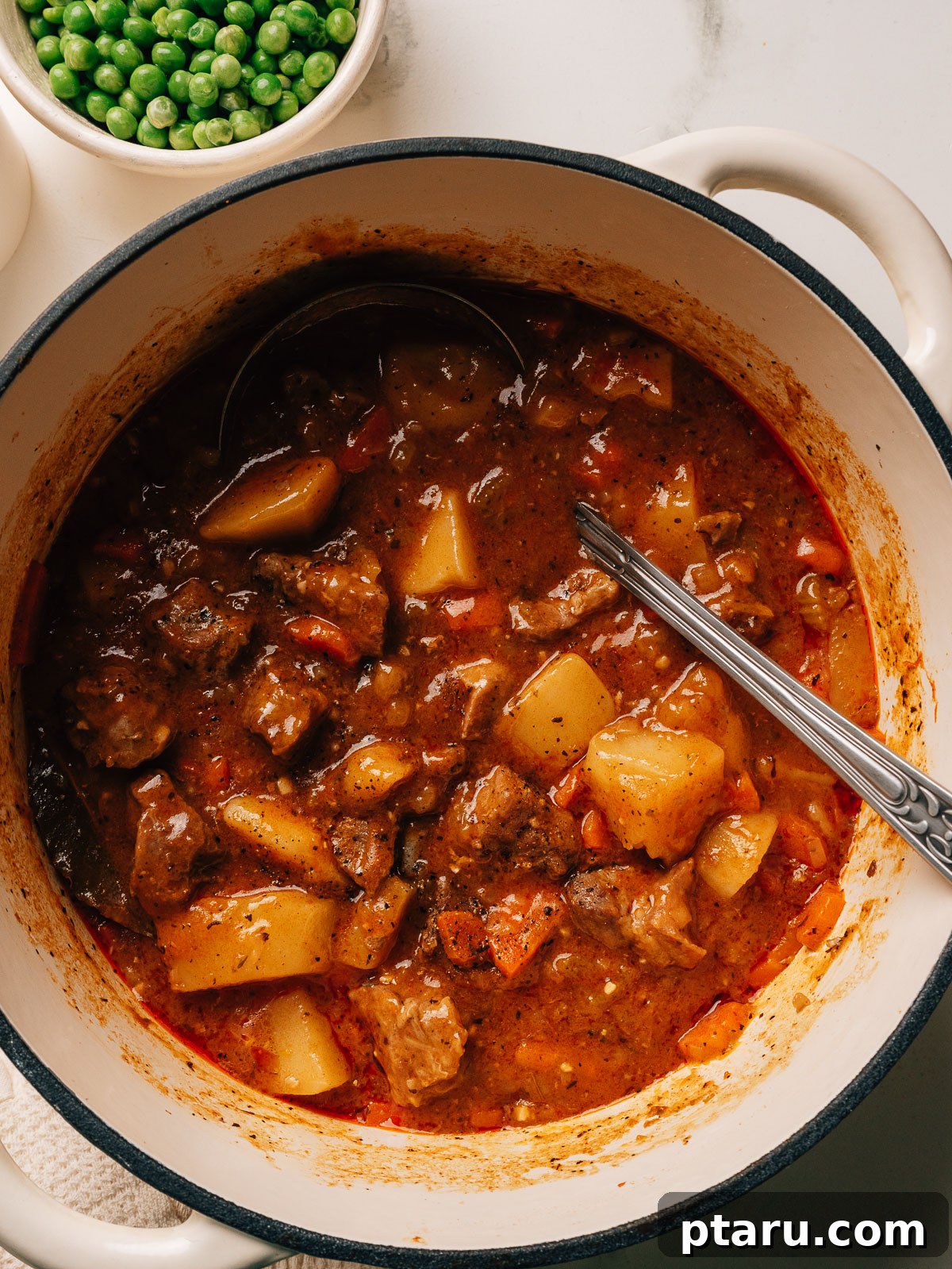 Savory Slow-Cooked Pork Stew with Vegetables 8 Pork stew in a dutch oven with a spoon.