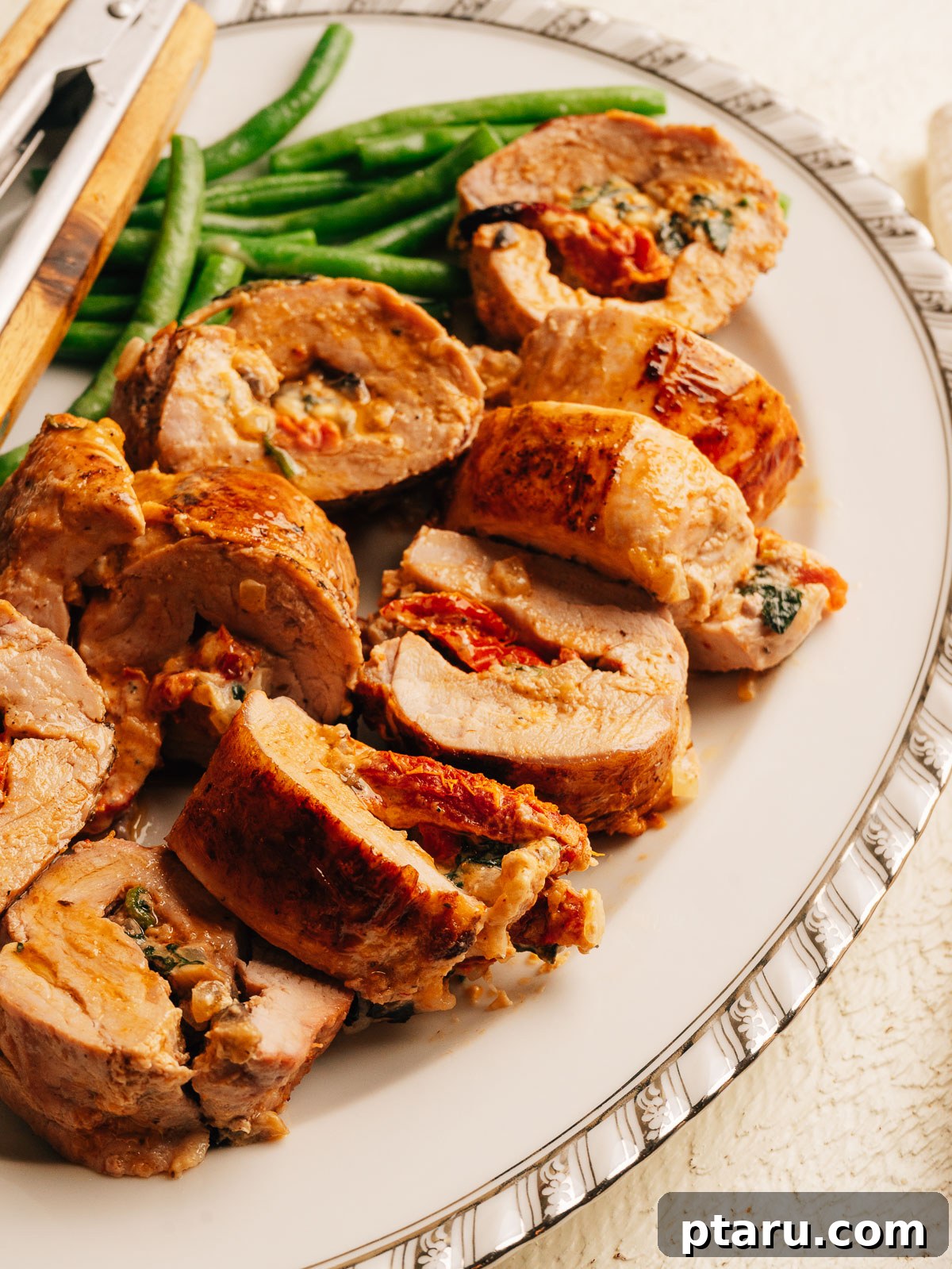 Creamy Mediterranean-Stuffed Pork Tenderloin: Tender Roast Recipe 11 Sliced stuffed pork tenderloin showing creamy sun-dried tomato and spinach filling.