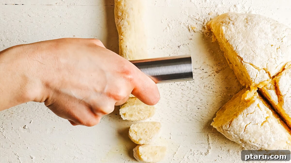 Rolling gnocchi dough into a rope and cutting it into bite-sized pieces