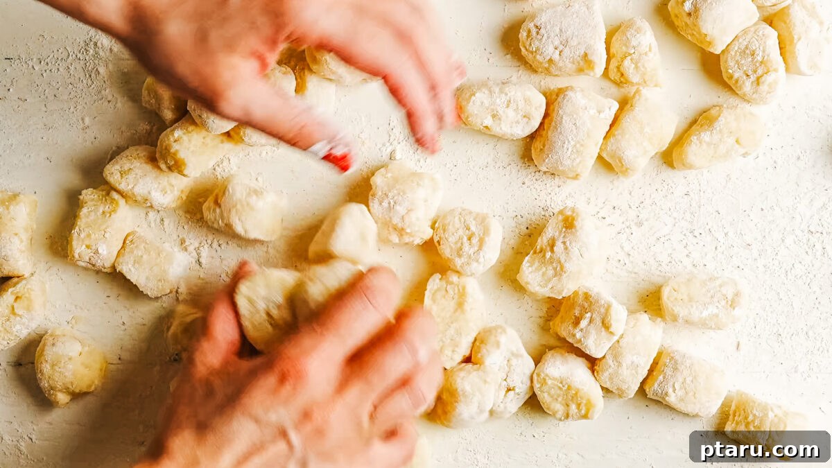 Shaping each gnocchi by rolling it along the tines of a fork to form ridges