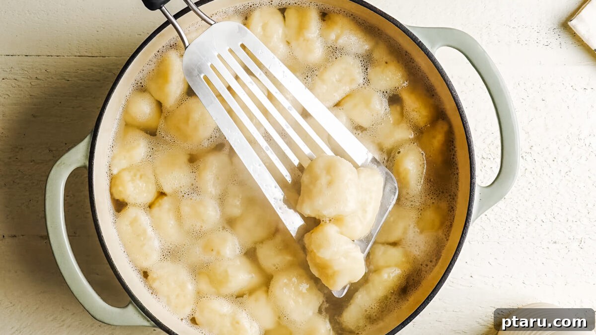 Cooked potato gnocchi floating in a pot of boiling water