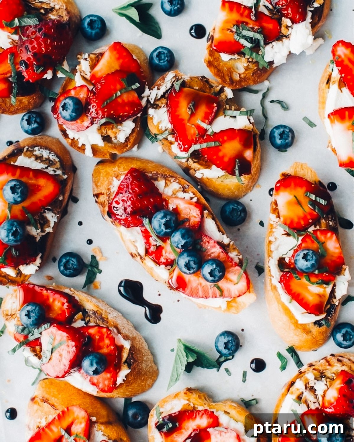 4th of July Recipes: Crowd-Pleasing Patriotic Dishes 2 Red, white and blue 4th of july crostini appetizers on a tray with blueberries and strawberries.