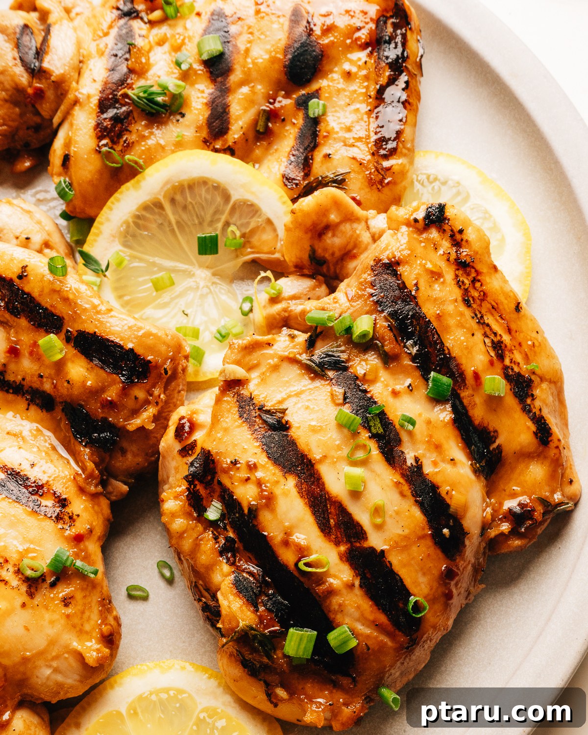 Grilled chicken thighs with balsamic chicken marinade on a plate.