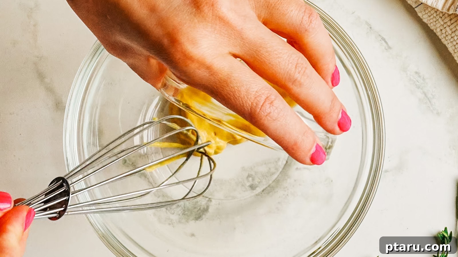 Whisking Dijon mustard in a glass bowl to start the marinade.