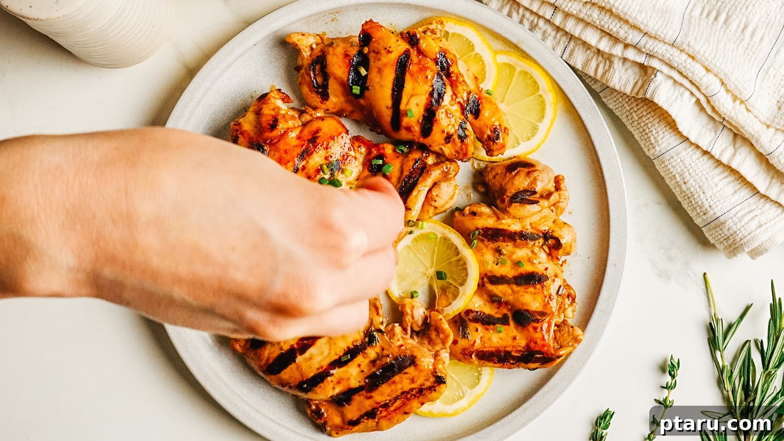 Squeezing fresh lemon over grilled balsamic chicken.