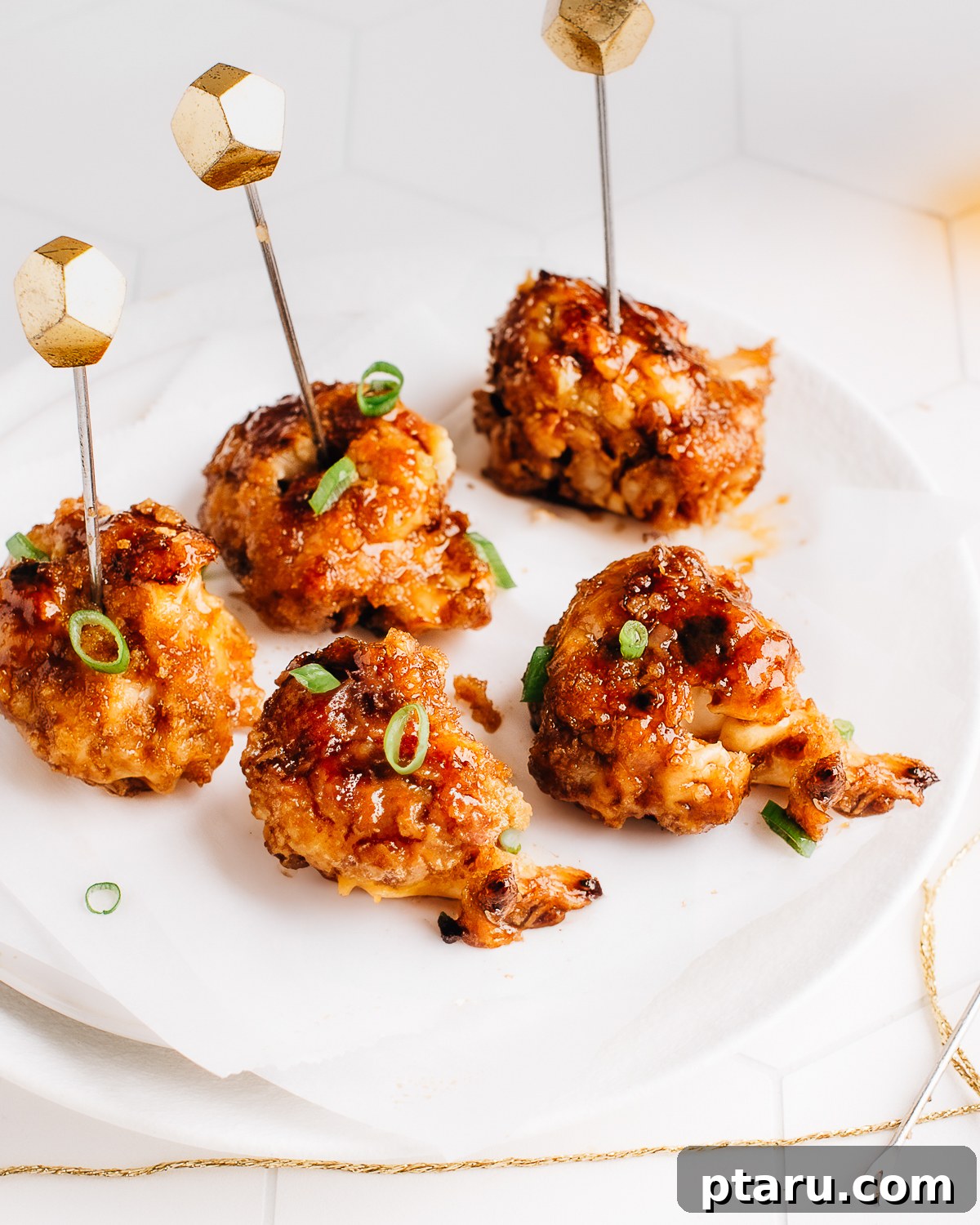 Crispy cauliflower wings on a plate with sticky sauce.