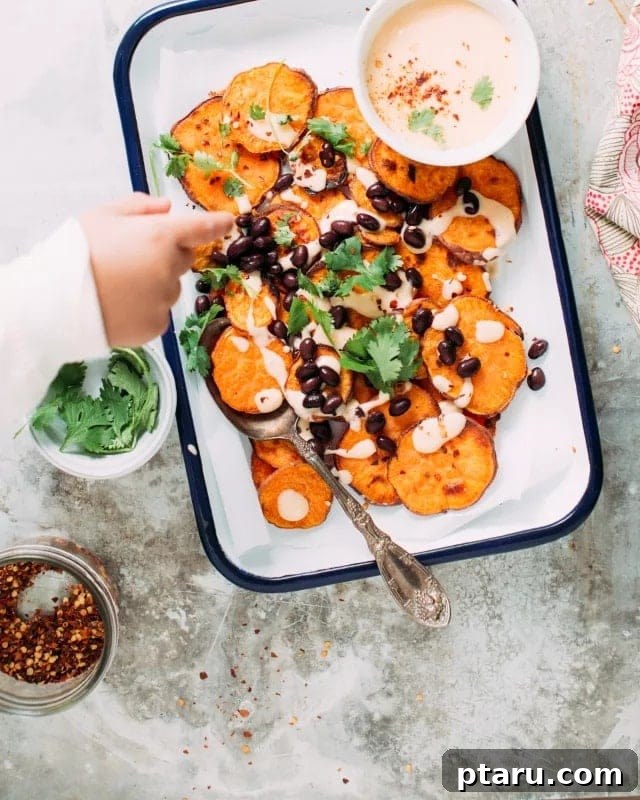 Sweet potato nachos topped with cheese sauce and toppings.