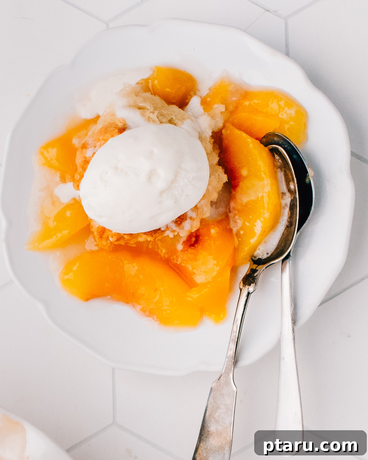 Peach cobbler in a baking dish with a golden biscuit topping.