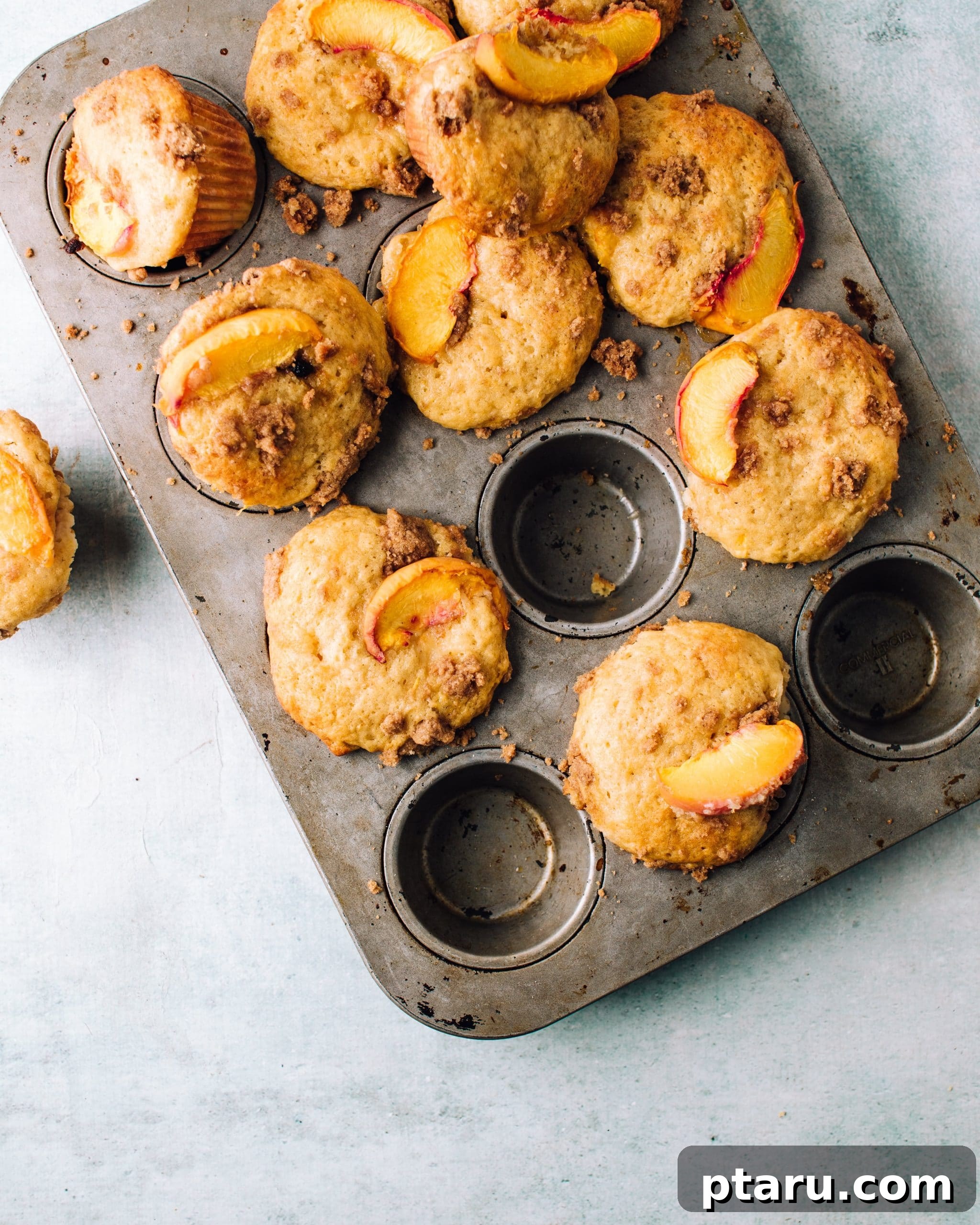 Peach streusel muffins in a baking pan.