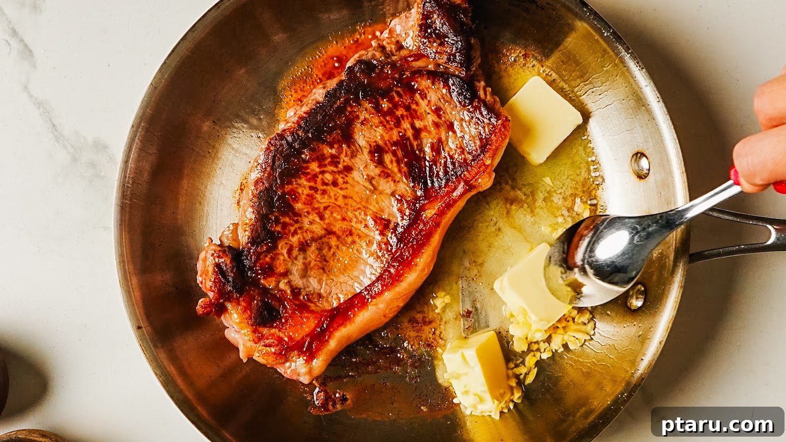 Pan-Seared Garlic Butter Steak in 15 Minutes 6 Spooning foaming garlic butter over the steak in the pan.