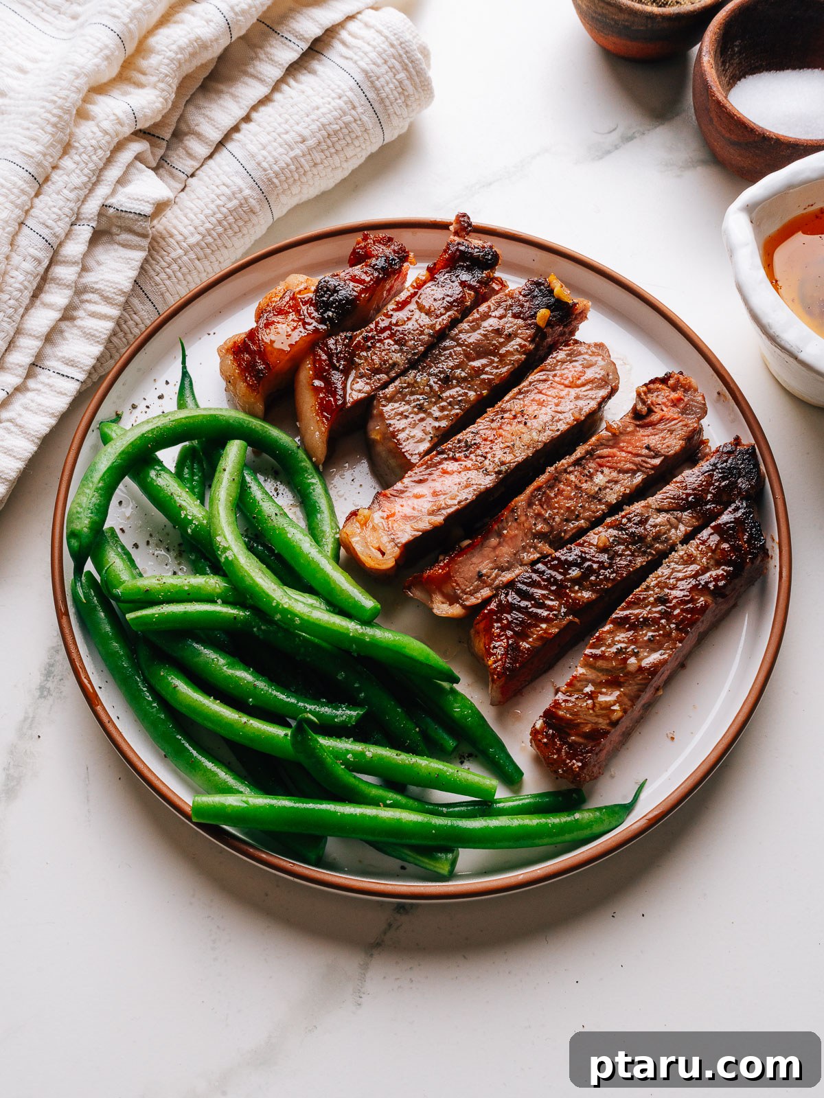 Pan-Seared Garlic Butter Steak in 15 Minutes 7 Garlic butter steak sliced and plated with green beans and pan butter.