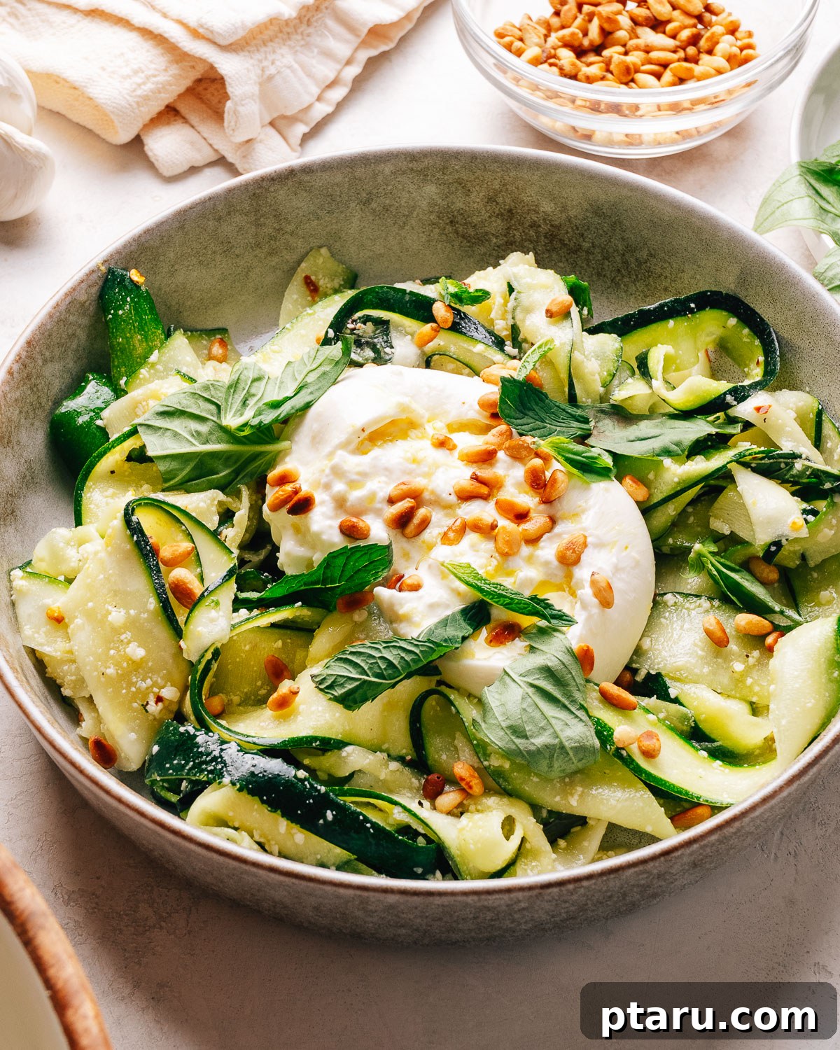 Zucchini Ribbon Salad with Lemon-Parmesan Vinaigrette 10 Zucchini salad with creamy burrata, toasted pine nuts, and fresh herbs in a bowl.