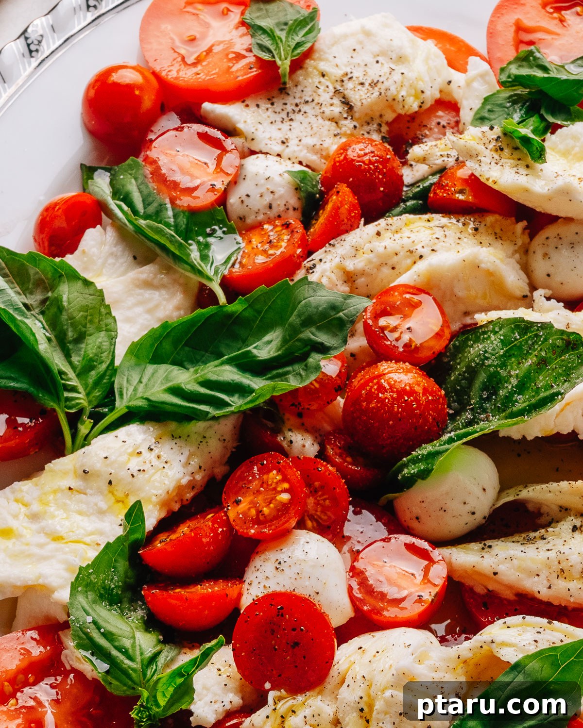 Authentic Caprese Salad with Cherry Tomatoes 7 Caprese salad recipe with cherry tomatoes on a platter with torn mozzarella, ripe tomatoes and fresh basil.