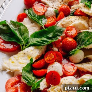 Authentic Caprese Salad with Cherry Tomatoes 8 Caprese salad recipe with cherry tomatoes on a platter with torn mozzarella, ripe tomatoes and fresh basil.