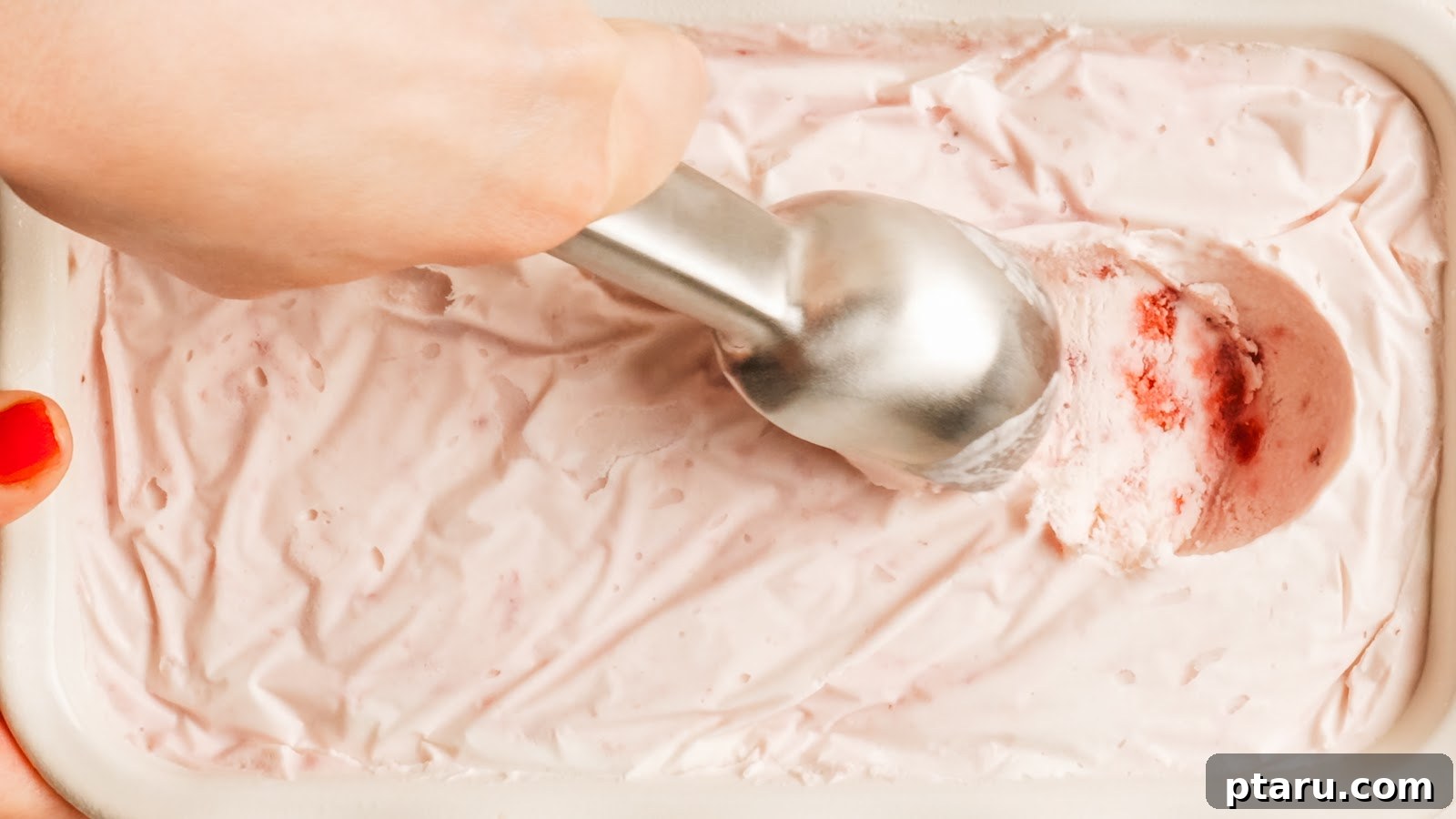 Close-up of a scoop of creamy homemade strawberry ice cream.