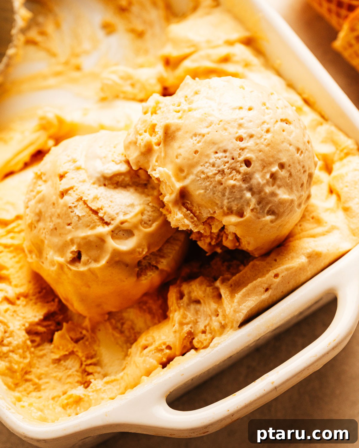 Scoops of homemade peanut butter ice cream in a dish.