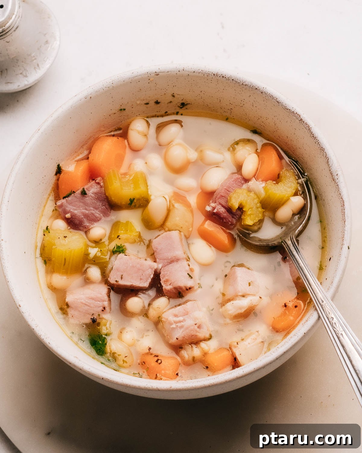 57 Comforting Soup Recipes for Every Occasion 11 Ham bone soup with beans, vegetables and shredded ham in a pot.