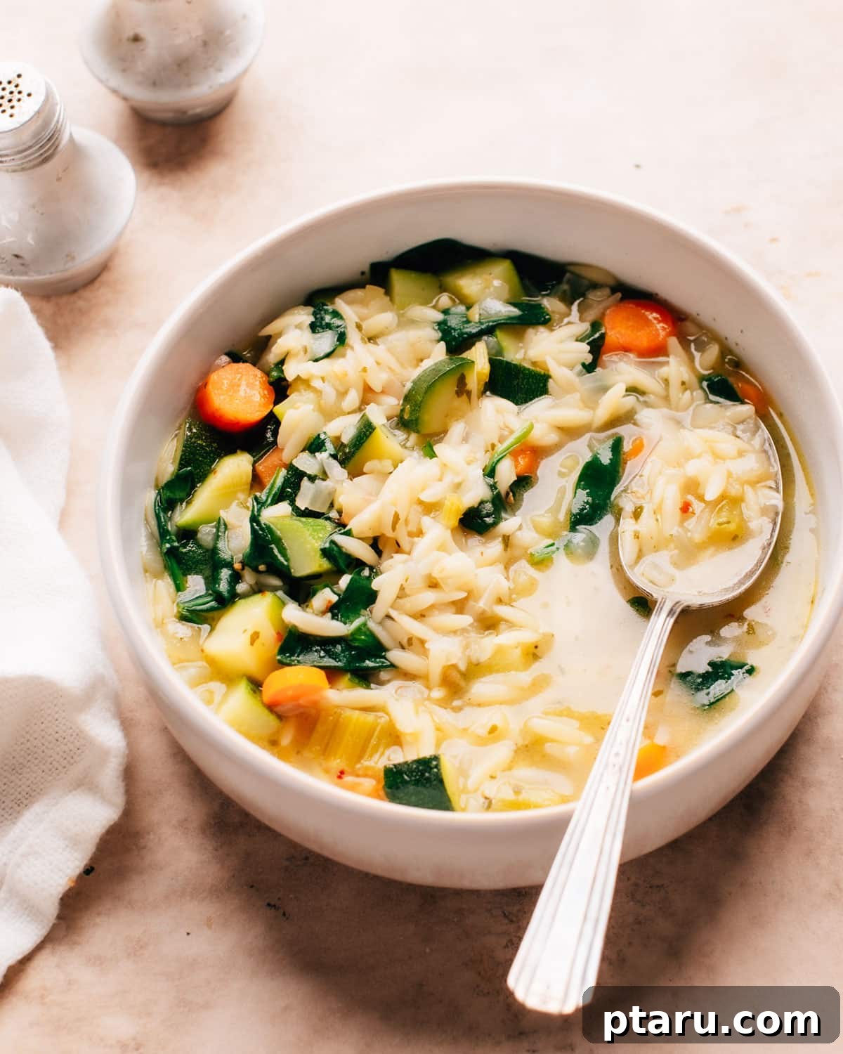 57 Comforting Soup Recipes for Every Occasion 16 Vegetable orzo soup with orzo pasta, carrots and greens in a bowl.