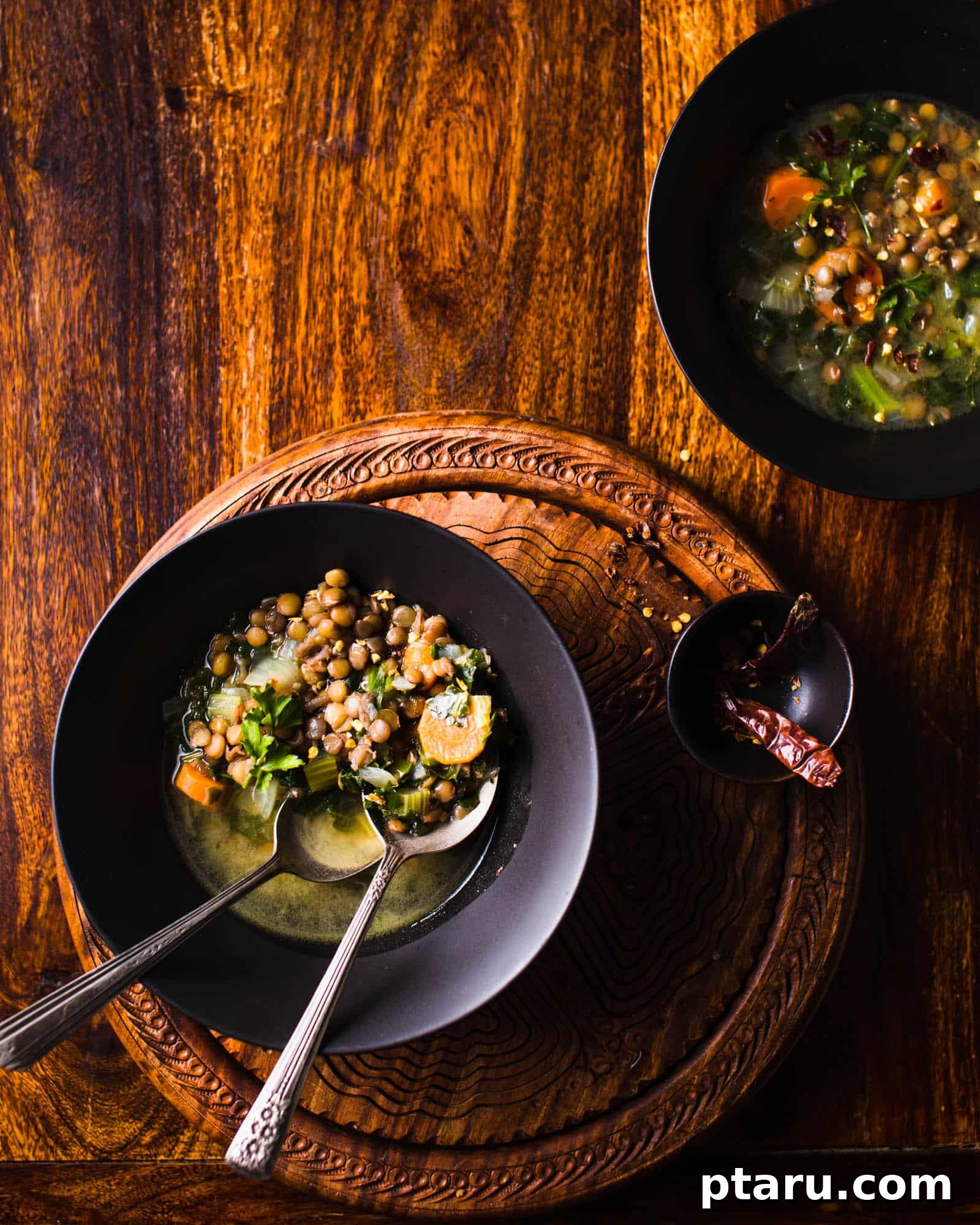 57 Comforting Soup Recipes for Every Occasion 20 Hearty lentil and kale soup in a rustic bowl with a spoon.