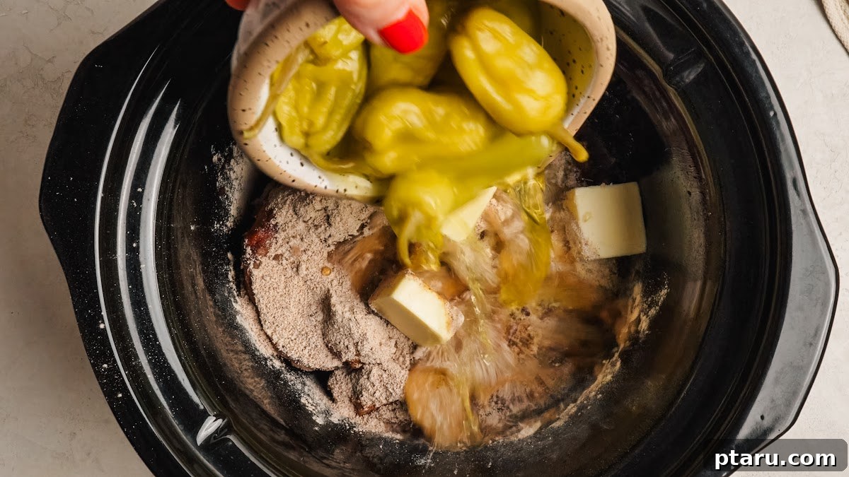 Slow-Cooker Mississippi Pot Roast 6 Butter pieces and whole pepperoncini added on top of the roast.