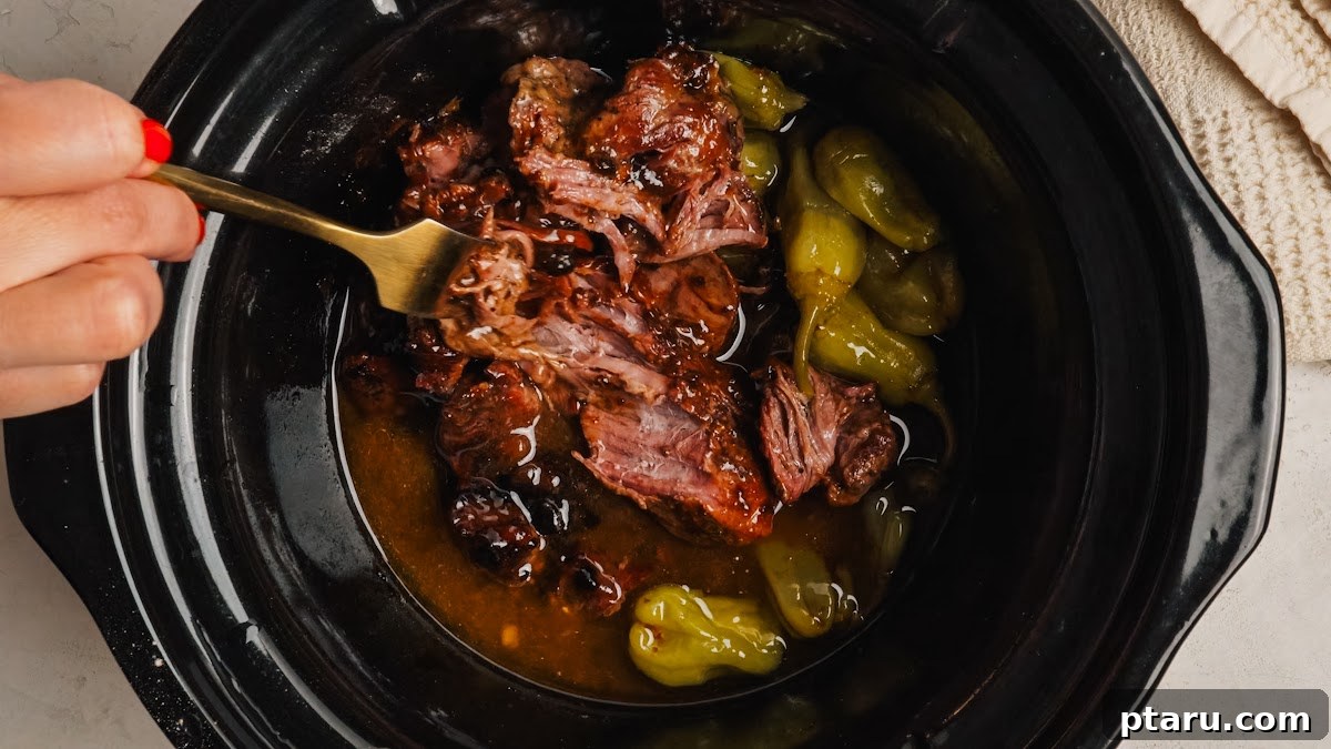 Slow-Cooker Mississippi Pot Roast 9 Shredding the cooked beef with two forks in its buttery juices.