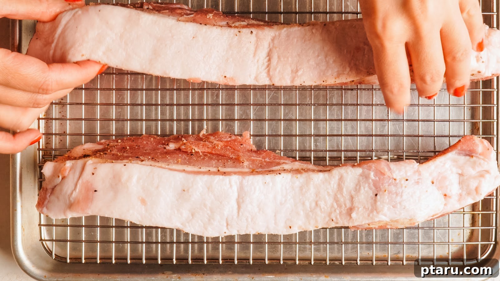 Slow-Roasted Pork Belly with Crispy Crackling 7 Pork belly set skin side up on a wire rack over a rimmed tray.