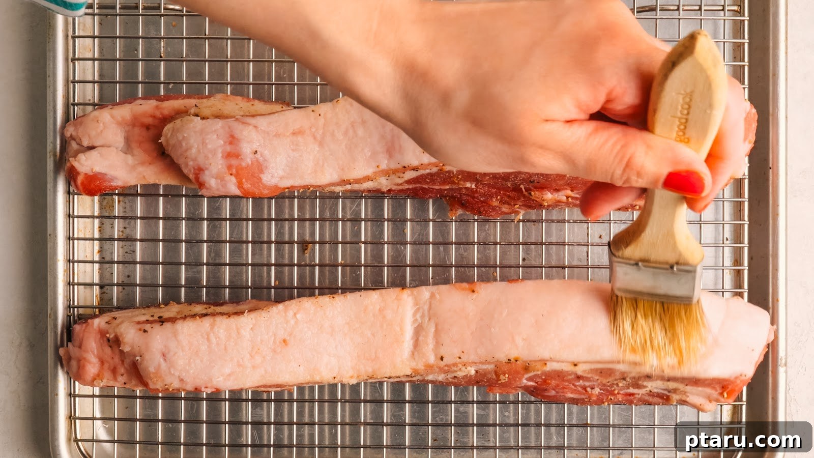 Slow-Roasted Pork Belly with Crispy Crackling 8 Brushing kosher salt over the pork belly skin on the rack.