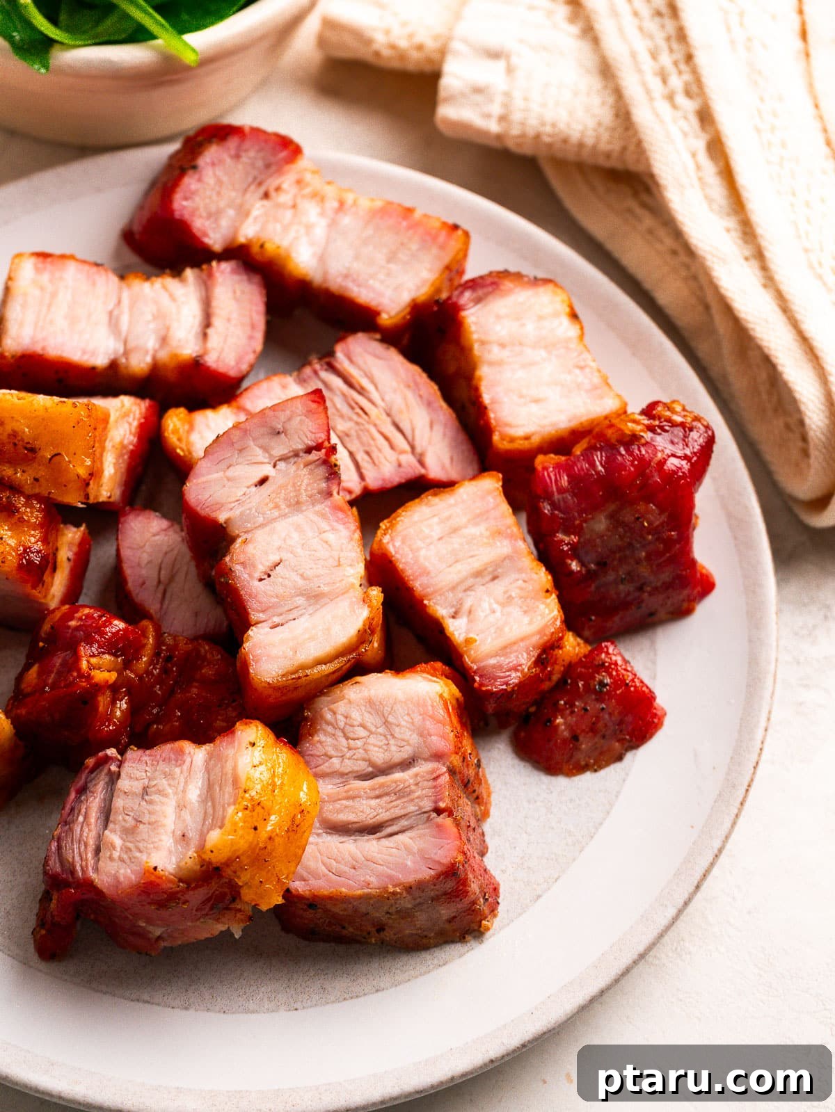Slow-Roasted Pork Belly with Crispy Crackling 10 Crispy pork belly pieces on a white plate.