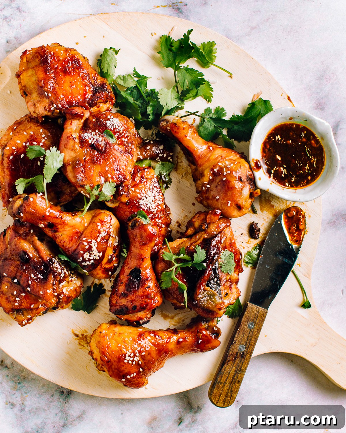 Homemade Honey BBQ Sauce Recipe 3 Baked chicken legs glazed with honey BBQ sauce on a plate with cilantro.