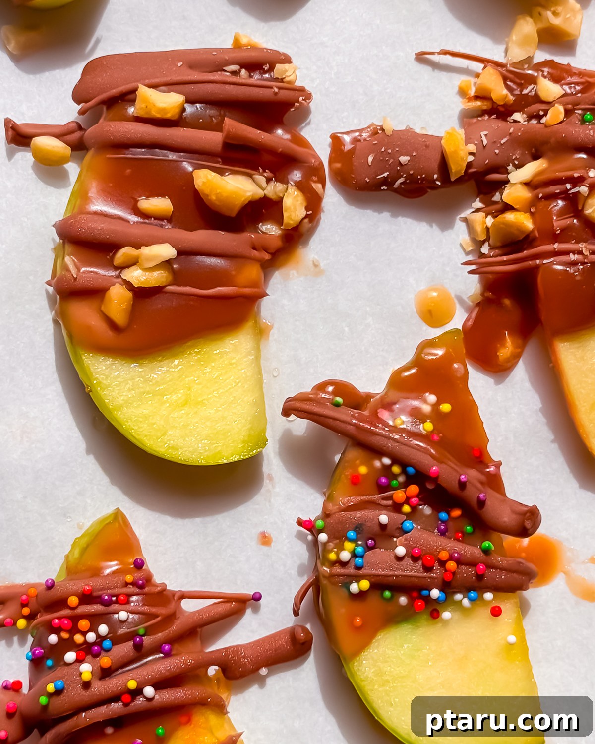Caramel Apple Slices with Homemade Caramel Sauce 4 Overhead tray of caramel apple slices topped with chocolate, peanuts and candy.